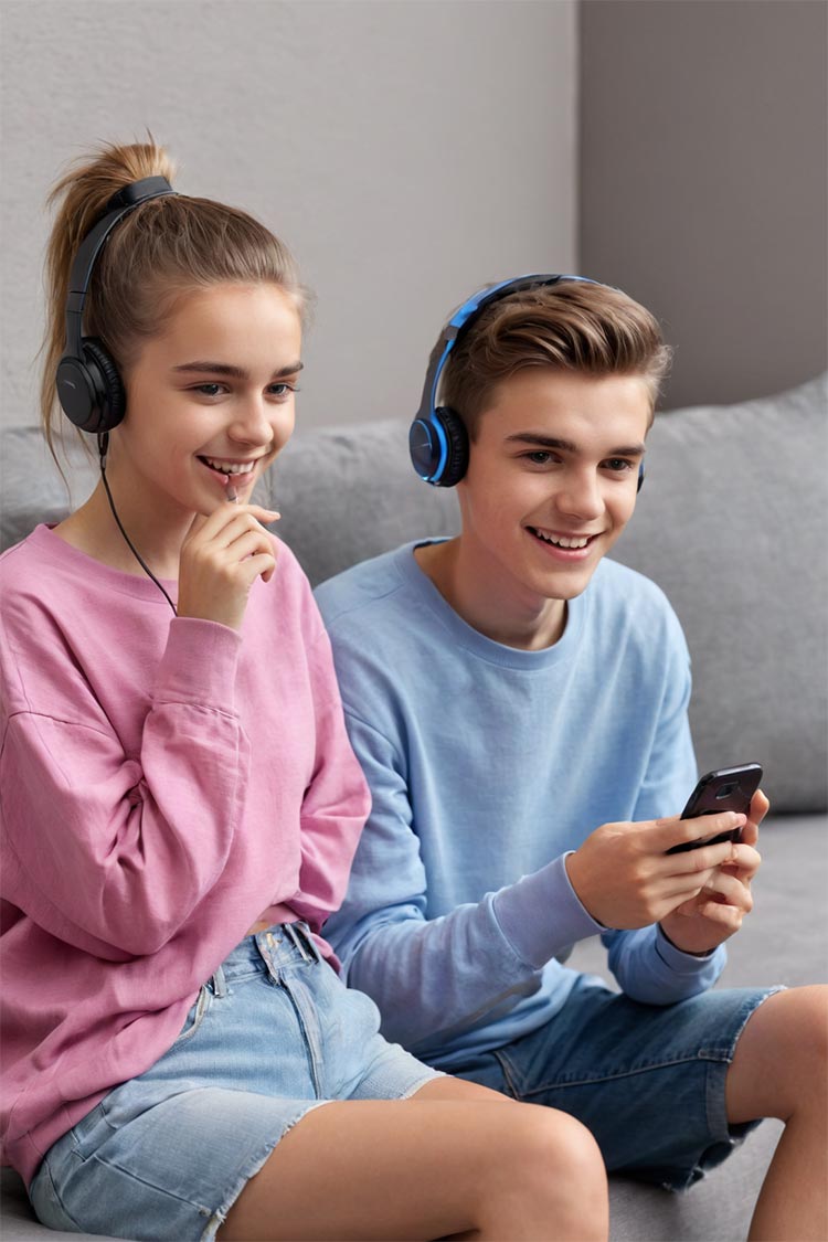 girl and boy teens in couch with headphones